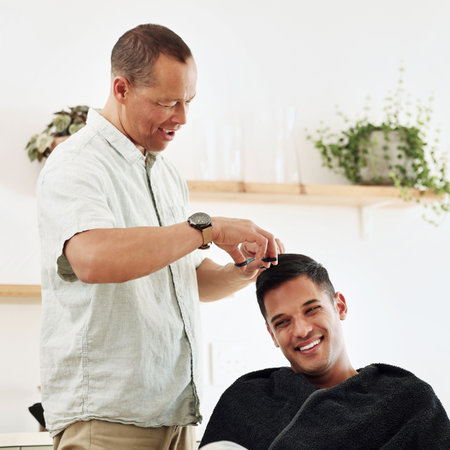 Father, man and shaving hair in home for grooming, cleaning and trimming. Smile, laughing and happy male or son getting haircut with electric shaver from senior dad for hairstyle and bonding in houseの写真素材