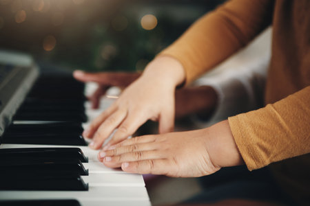 Learning, piano and hands of a child and parent playing a song together. Education, music and zoom of a kid with a dad teaching an instrument during a musical lesson, help and showing to playの写真素材