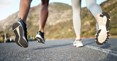 Together is always better. a couple out for a run on a mountain road.の写真素材