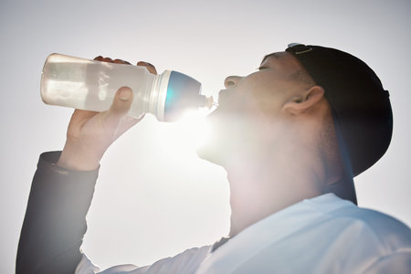 Baseball player, drinking water or thirsty sports man on field in training match or game in a...