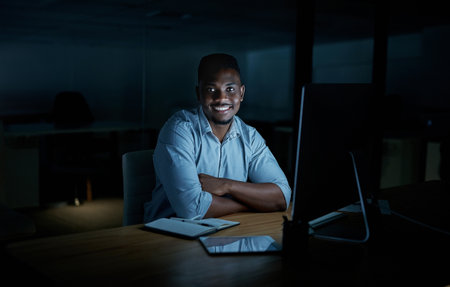 The right time is right now. Portrait of a young businessman using a computer during a late night at work.の写真素材
