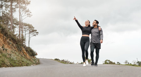 Birdwatching while were working out. Full length shot of two young athletes walking with their arms around each other after a run outdoors.の写真素材