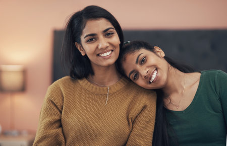 My sister truly is my best friend. two happy young women sitting together at home.の写真素材