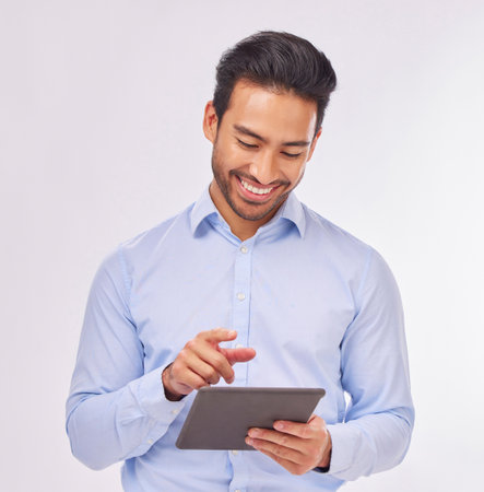 Typing, smile and business man with tablet in studio isolated on a white background. Professional, technology and happy male with touch screen for social media, research or internet browsing online.の写真素材