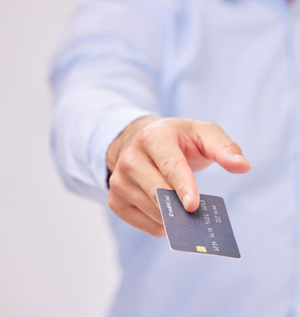 Credit card in hand, payment and shopping with man, purchase product or service isolated on white background. Closeup, commerce and customer, buying with promotion and sale, shop and male in studioの写真素材