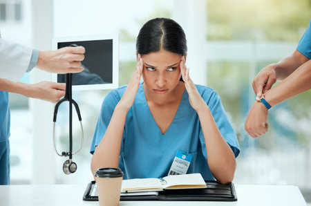 What else do I have to deal with today. a young female doctor looking stressed out in a demanding work environment.の写真素材