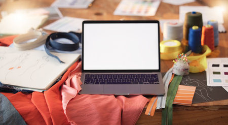 Mockup, design and a laptop screen for fashion, maunfacturing and clothing tailoring. Creative, blank and computer on a table for creativity, clothes ideas and styling for a dressmaker or designerの写真素材
