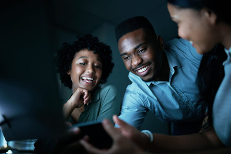 Creative minds are in constant motion. a group of young businesspeople using a smartphone and...