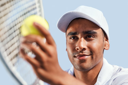 My opponent isnt going to get this. a handsome young man standing alone and looking contemplative before serving the ball during a tennis match.の写真素材