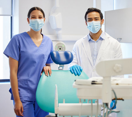 Crafting beautiful smiles are what were best at. Portrait of a young dentist and his assistant working in their consulting room.の写真素材