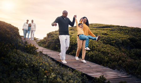 Family, walking or sunset with parents, kids and grandparents playing together outdoor in nature. Spring, love or environment with children and senior relatives taking a walk while bondingの写真素材