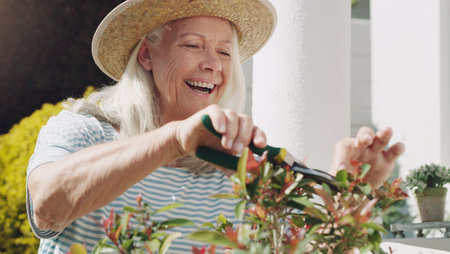Ive picked up gardening as a hobby. a senior woman standing alone in her garden and pruning her plants during the day.の写真素材