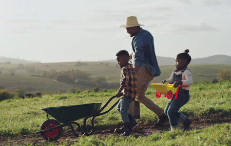We nurture the earth, we nurture our family. a mature man working his adorable son and daughter on a farm.の写真素材
