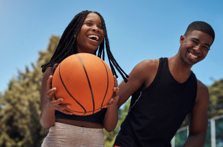 You dont need a big crowd to get a good game going. two sporty young people playing basketball on a sports court.の写真素材