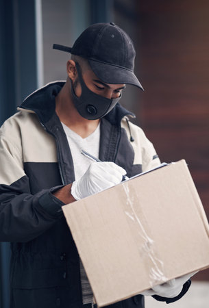 The most trustworthy track record in the service field. a masked young man delivering a package to a place of residence.の写真素材