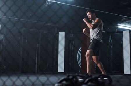 The technique that earned him his body. a young man practicing his kickboxing routine at a gym.の写真素材