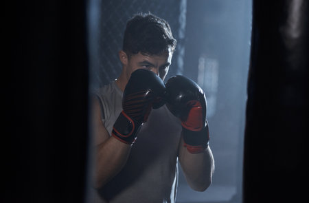 Strong is an attitude. a young man practicing his boxing routine at a gym.の写真素材