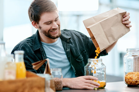 Decant your groceries and send that virus packing. a young man packing his groceries into glass...