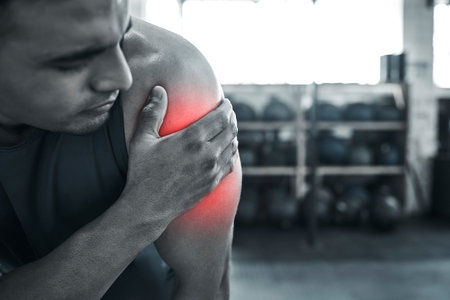 Arm pain can stop any trainer. Young, fit athlete with arm injury. Bodybuilding can be a painful sport. No workout is without pain. Red CGI spots of pain can occur.Young man with a bicep crampの写真素材