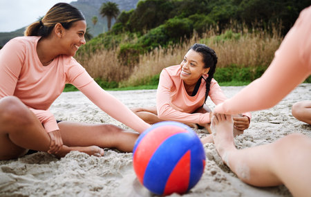 Volleyball, stretching and women with ball on beach ready to play match, competition and sports game. Teamwork, fitness and female players stretch on sand for warm up practice, training and exerciseの写真素材