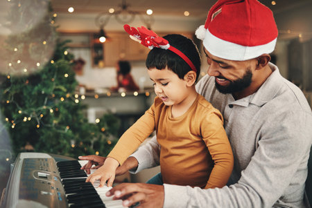 Happy father, child and piano for christmas celebration, songs and xmas hymn at home. Parent, boy kid and teaching keyboard instrument, festive music and celebrate fun holiday spirit with audio soundの写真素材