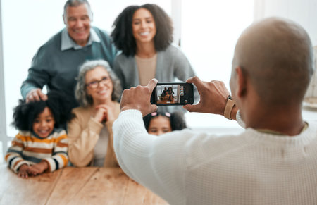 Love, smile or phone photography with happy family in living room for social media, bonding or relaxing. Happiness, pictures or generations with grandparents or children at home for memory or supportの写真素材