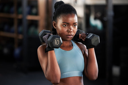 Your excuses are invalid. a sporty young woman working out with dumbbells at the gym.