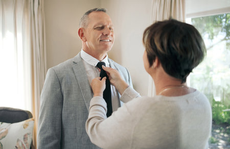 You keep my looking sharp. a mature woman helping her husband fix his tie.の写真素材