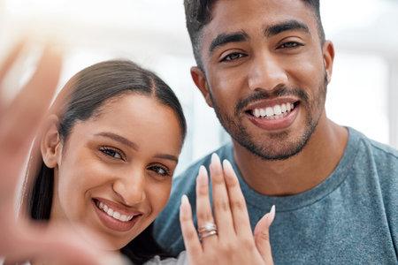 Were engaged. a young couple standing together and taking a selfie to celebrate their engagement.の写真素材