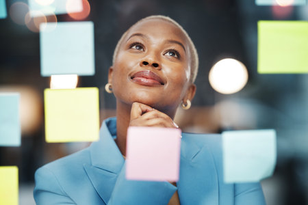 Vision, thinking and black woman with schedule, planning and agenda, sticky notes and bokeh background. Idea, face and female leader with goal, visual and problem solving, calendar and managementの写真素材