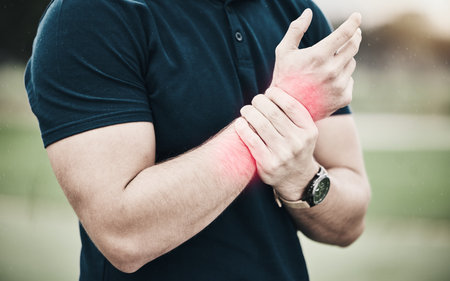 Sport, injury and golf, man with wrist pain during game on course, massage and outdoor relief in health and wellness. Green, hands on arm in support and golfer with ache from swing in golfing workoutの写真素材