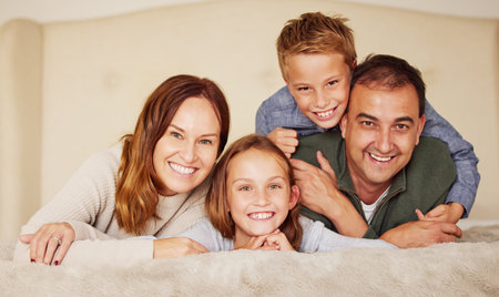 Love and happiness live in our home. a young family lying on the bed together and bonding during a day at home.の写真素材