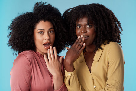All good conversations start with, Girrrrrrl. Studio shot of two young women looking shocked against...