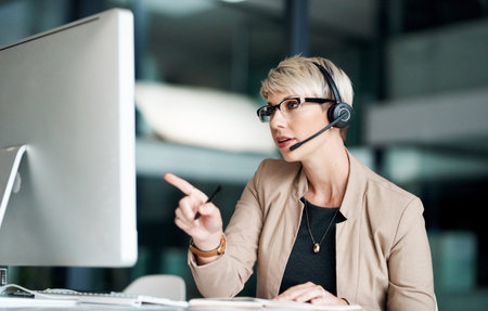 Going the extra mile is simply what we do. a young businesswoman wearing a headset while working on...