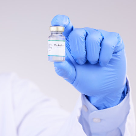 Vaccine, doctor hands and monkeypox bottle for safety, medicine and healthcare innovation in studio. Closeup vaccination, person and liquid vial for drugs, medical virus and pharmaceutical researchの写真素材