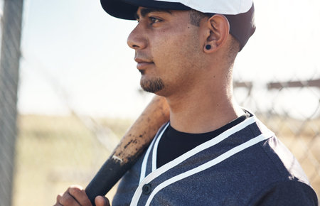 The field better be ready for me. a young man holding his bat at a baseball game.
