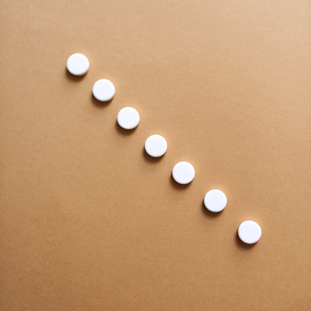 Something to get you feeling better. Studio shot of a row of white tablets against a brown...