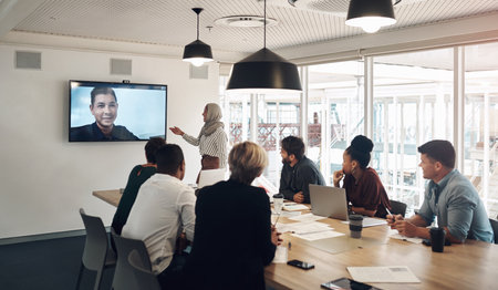 Distance is nothing in the face of technology. a group of business colleagues gathered in the boardroom for a video conference.の写真素材