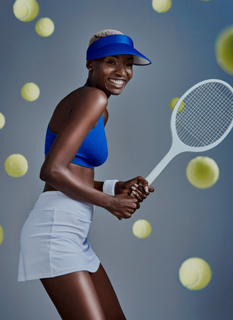 Tennis is like therapy. Studio shot of a sporty young woman posing with tennis equipment against a grey background.の写真素材