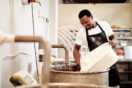 Lets start the kneading process. a baker pouring flour into a kneading machine.
