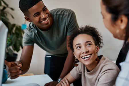 With teamwork anything is possible. a group of young businesspeople using a computer together in a modern office.の写真素材
