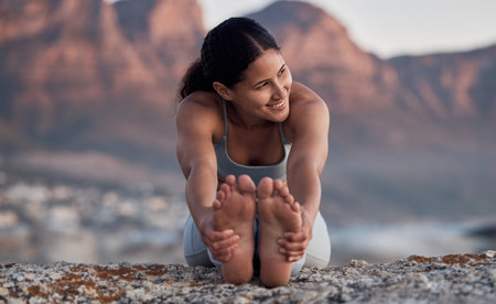Fitness, yoga and stretching with a woman on the beach for wellness, mental health or exercise in nature. Environment, peace and thinking with a female athlete doing a warm up for zen trainingの写真素材