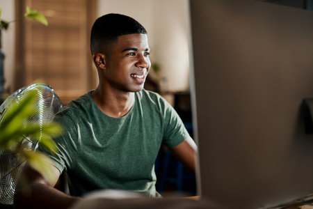 Something satisfying about doing what you love. a young businessman using a computer in a modern office.の写真素材