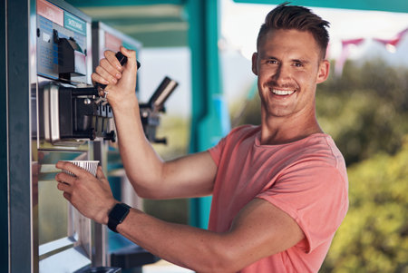 He loves his job. Portrait of a cheerful young coffee barista pouring a cup of coffee to serve to a customer outside next to his coffee truck.の写真素材