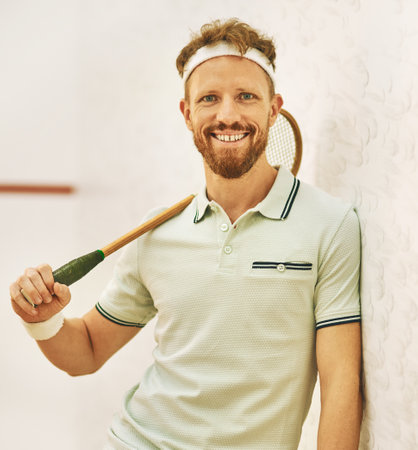 Meet the squash champion himself. a confident young man standing on a squash court.の写真素材