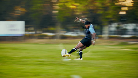 Rugby, action and black man kicking ball to score goal on field at game, match or practice workout. Sports, fitness and motion, player running to kick at poles on grass with energy and skill in sportの写真素材