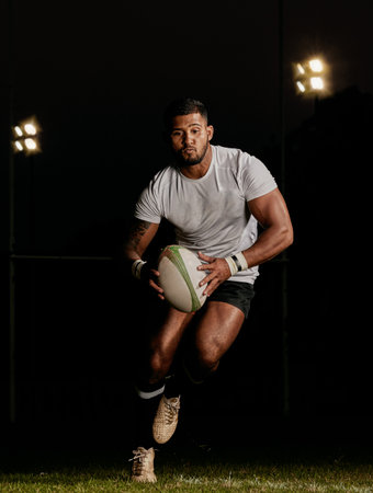 Rugby, night and man running with ball to score goal at dark stadium at game, match or practice workout. Sports, fitness and motion, player with action on grass with energy and skill in team sport.の写真素材