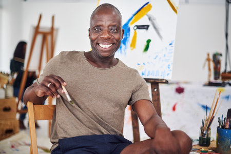 Im happy as long as I can paint. a middle aged man smiling at the camera in a art studio.の写真素材