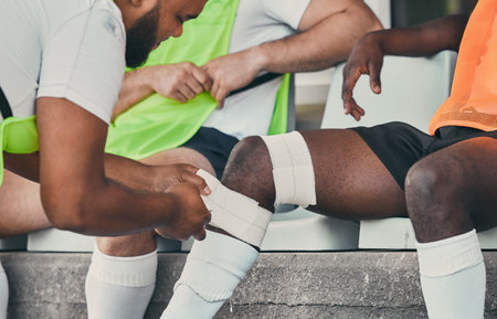 Bandage, legs injury and man with medic after practice match, training and sports game in stadium. Medical emergency, health worker and rugby athlete with joint inflammation, accident and tendinitisの写真素材