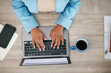 Woman, hands and laptop typing above for email, business proposal or digital report on office desk. Top view of female employee hand working on computer in communication or networking at workplaceの写真素材